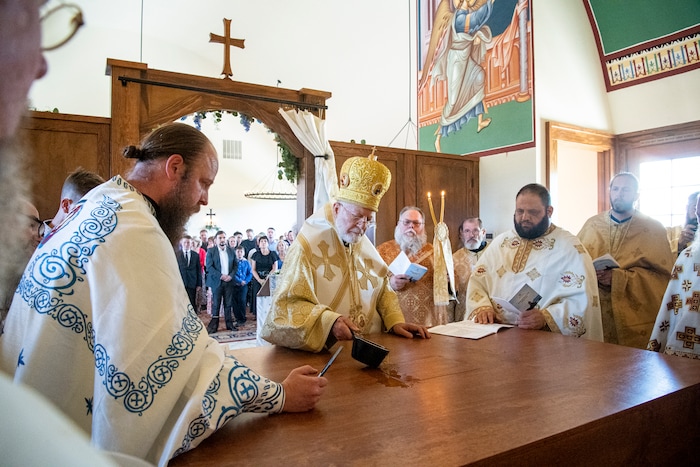 (Isaac Hale | Special to The Tribune) Metropolitan Joseph, leader of the Antiochian Orthodox Christian Archdiocese of North America, pours holy water on the holy table as he and other clergy prepare to wash it during a consecration service for St. Xenia Orthodox Church in Payson on Saturday, July 16, 2022.