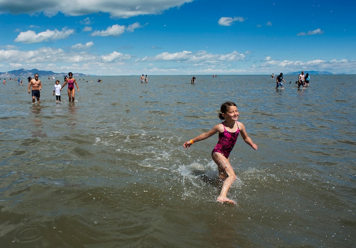 (Rick Egan  |  The Salt Lake Tribune)    Six-year-old Thalia Story splashes through the water at the Great Salt Lake ahead of her family, as they brave the cool temperatures Saturday morning, June 8, 2019.