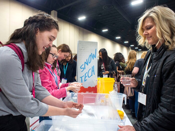 (Rick Egan  |  The Salt Lake Tribune)         Anna Jensen (left), from AISU, holds super absorbent polymer in her hand, as volunteer Melanie Clark (right) assists, at the InstaSnow exhibit, during the SheTech Explorer Day event, which helps integrate girls with 150 technology companies, at the Mountain America Expo Center in Sandy, Tuesday, April 9, 2019.