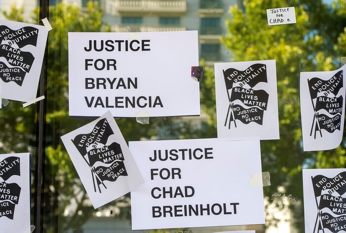 (Rick Egan  |  The Salt Lake Tribune)     Protesters put new signs on the Salt Lake District Attorney's Office, during a protest to draw attention to Chad Breinholt and Bryan Valencia, who, like Bernardo Palacios were killed by the police, Wednesday, July 8, 2020.