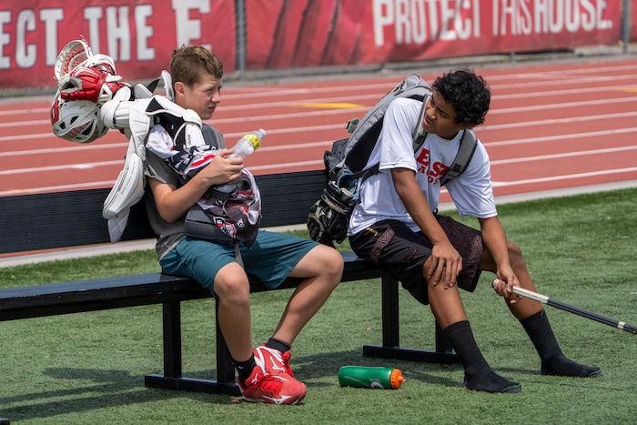 (Rick Egan | The Salt Lake Tribune)  Reilly Pearson-Ortolani chats with Lolo Angilau, after East youth lacrosse practice, on Wednesday, June 22, 2022.