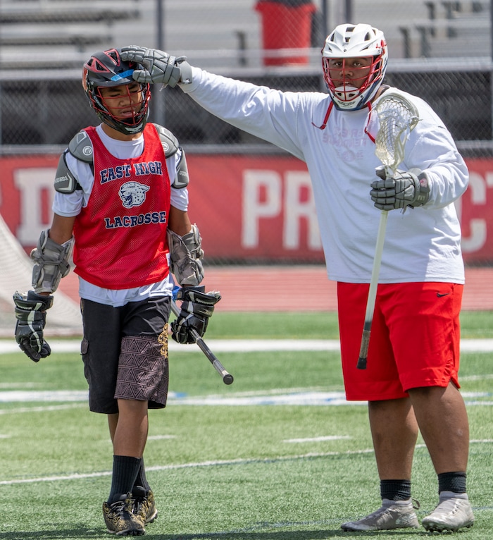 (Rick Egan | The Salt Lake Tribune)  Lolo Angilau gets a tap on the head from Tui Tonga, during East youth lacrosse practice, on Wednesday, June 22, 2022.
