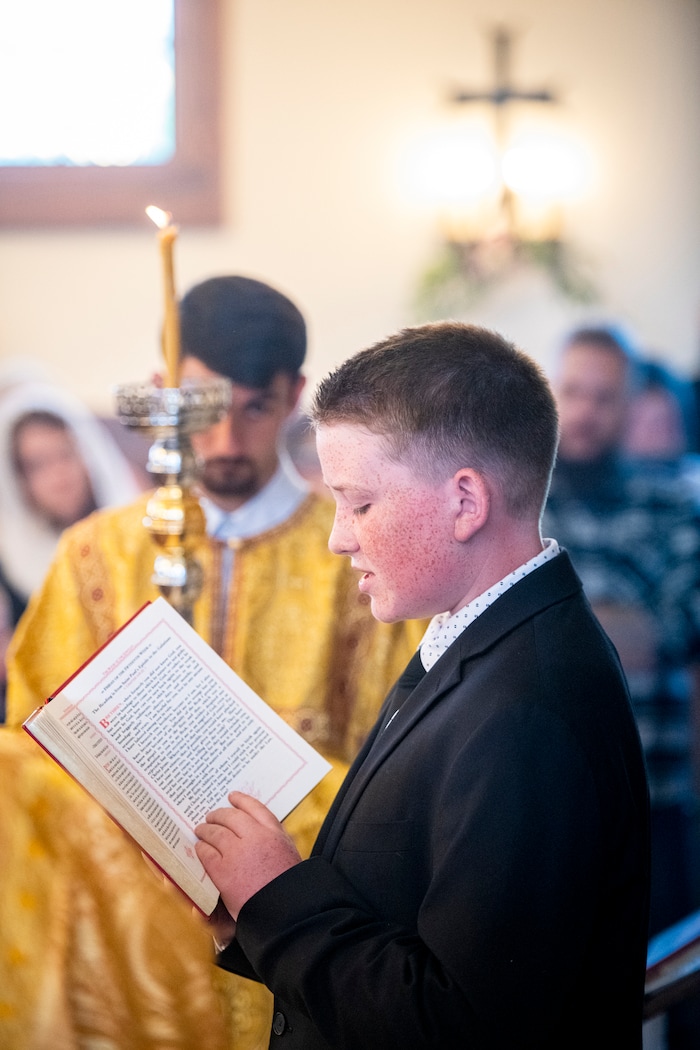 (Isaac Hale | Special to The Tribune) Benjamin Havens, 12, reads during a consecration service for St. Xenia Orthodox Church in Payson on Saturday, July 16, 2022.