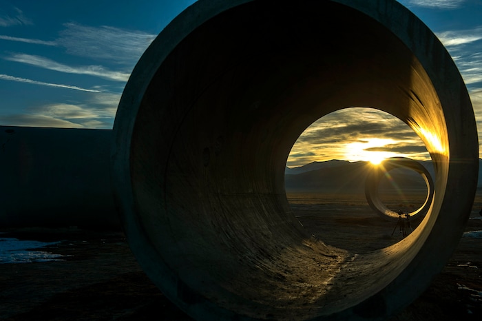 (Rick Egan | The Salt Lake Tribune)  The sun sets through the famed Sun Tunnels sculpture, during a unique winter solstice in remote Utah's Great Basin Desert, on Monday, Dec. 21, 2020.