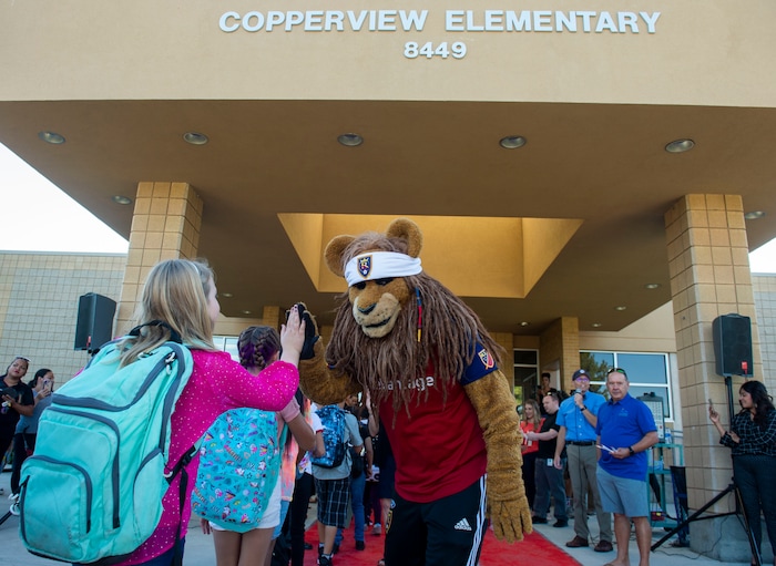 (Rick Egan | The Salt Lake Tribune)      Real Salt Lake mascot Leo the Lion gives high-fives to students as they walk the red carpet on the first day of school at Copperview Elementary School in Midvale, Monday, Aug. 19, 2019.