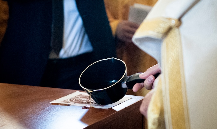 (Isaac Hale | Special to The Tribune) Metropolitan Joseph, leader of the Antiochian Orthodox Christian Archdiocese of North America, seals the four icons of the Holy Evangelists into the four corners of the holy table with hot wax during a consecration service for St. Xenia Orthodox Church in Payson on Saturday, July 16, 2022.