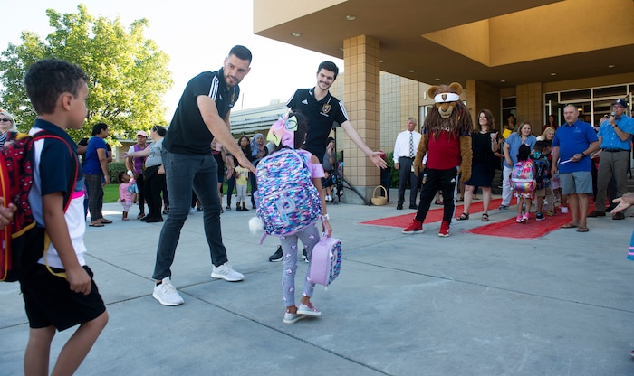 (Rick Egan  |  The Salt Lake Tribune) Real Salt Lake players and mascot Leo the Lion high-five students as they walk the red carpet on the first day of school at Copperview Elementary School in Midvale, Monday, Aug. 19, 2019.
