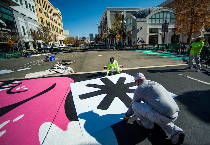 (Rick Egan | The Salt Lake Tribune). Workers paint the crosswalk at the intersection of 100 South and Rio Grande Street, on Wednesday, Nov. 4, 2020.