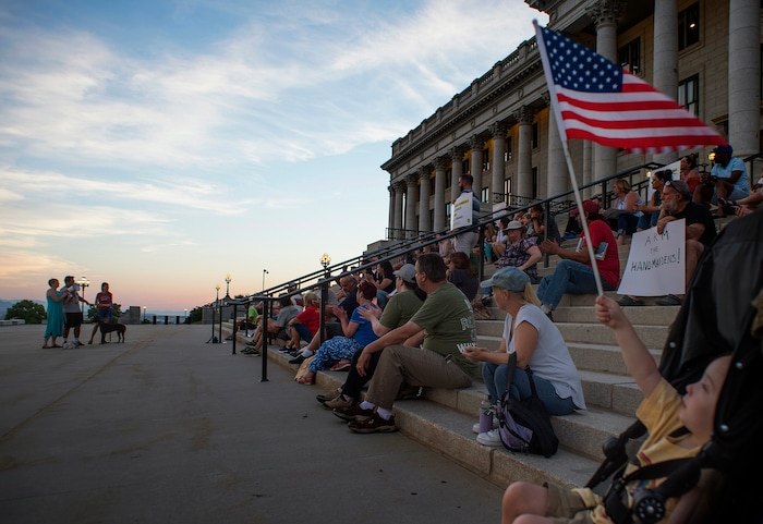 (Rick Egan  |  The Salt Lake Tribune)     Ezra Weitz waves a flag at the Confront Corruption Vigil at the Utah State Capitol, Wednesday, July 18, 2018.