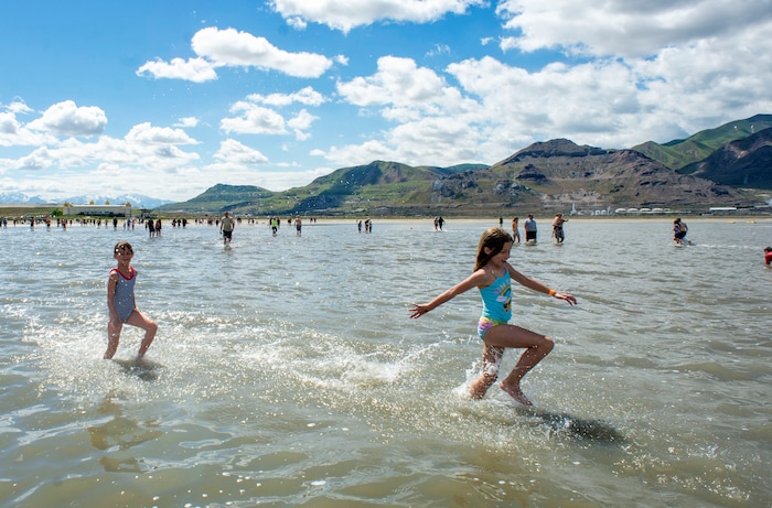 (Rick Egan  |  The Salt Lake Tribune)       Evey Hulderson, 9 and Bridgett Smit, 9, don't seem to mind the cold temperature as they splash through the water at the Great Salt Lake Saturday, June 8, 2019.  The cool temperatures resulted in a crowd of around 300 people, so the attempt to break the world record was turned into a polar plunge.