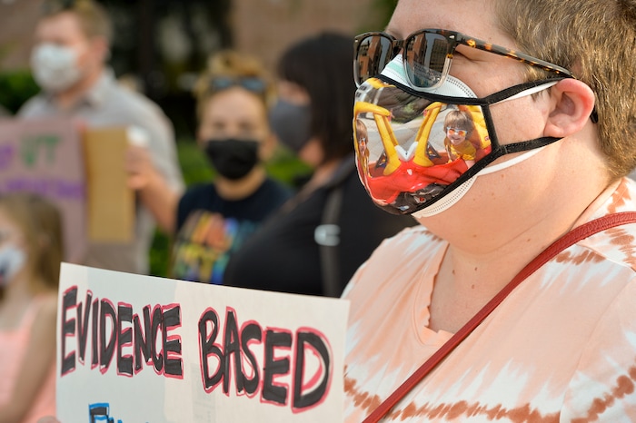 (Chris Samuels | The Salt Lake Tribune) Katie Nelson participates in a rally advocating mask use in schools outside the Utah Board of Education building, Friday, Aug. 6, 2021. Nelson worries that her son, seen on her mask, a preschooler with health conditions, may not be protected from contracting coronavirus if masks are not mandated in schools.
