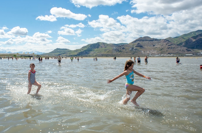 (Rick Egan  |  The Salt Lake Tribune)       Evey Hulderson, 9 and Bridgett Smit, 9, don't seem to mind the cold temperature as they splash through the water at the Great Salt Lake Saturday, June 8, 2019.  The cool temperatures resulted in a crowd of around 300 people, so the attempt to break the world record was turned into a polar plunge.