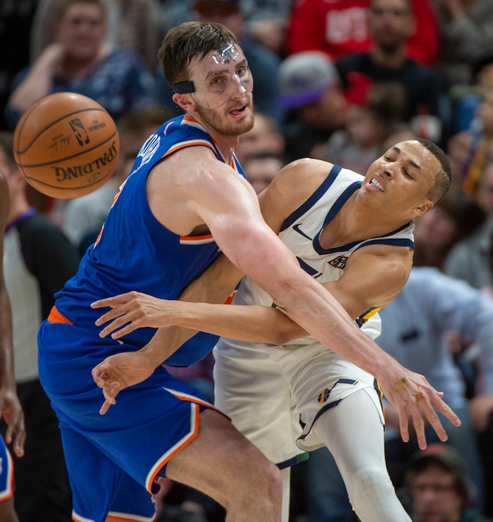 (Rick Egan  |  The Salt Lake Tribune) Utah Jazz guard Dante Exum (11) tosses a pass around New York Knicks forward Luke Kornet (2)), in NBA action between Utah Jazz and New York Knicks, in Salt Lake City, Saturday, Dec. 29, 2018.