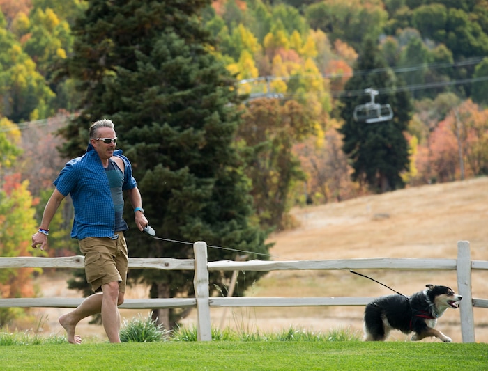 (Rick Egan  |  The Salt Lake Tribune)   Leland Smith runs with his dog, Luke, at the Blues, Brews & BBQ festival, at Snowbasin resort, Sunday, Sept. 23, 2018.